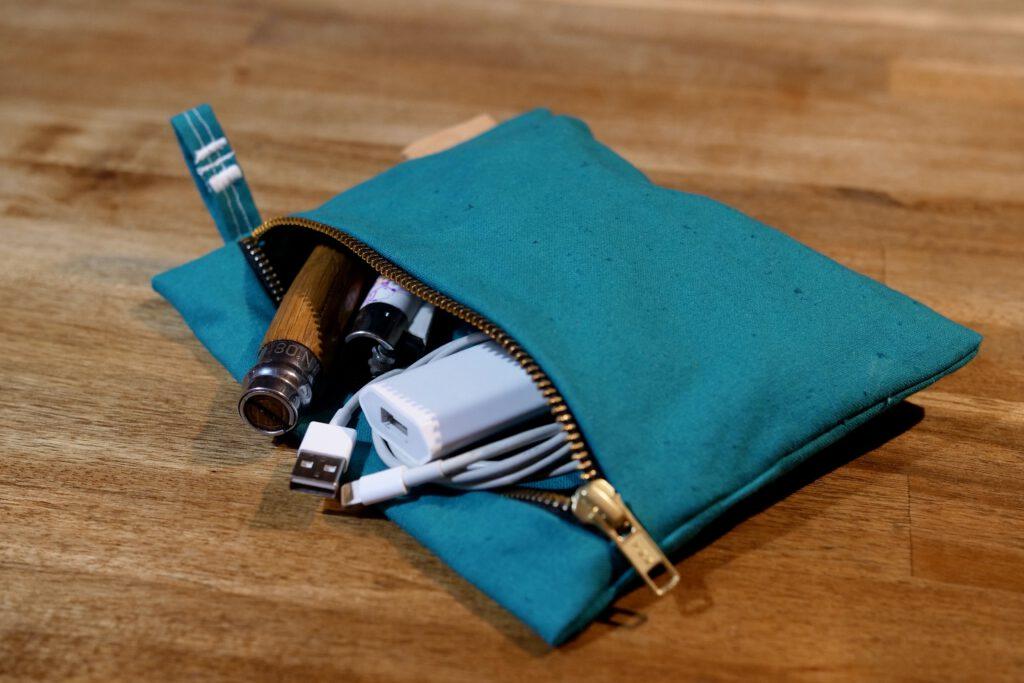 Zipperbag von kirschpack in Petrol mit geöffnetem Reißverschluss und Inhalt