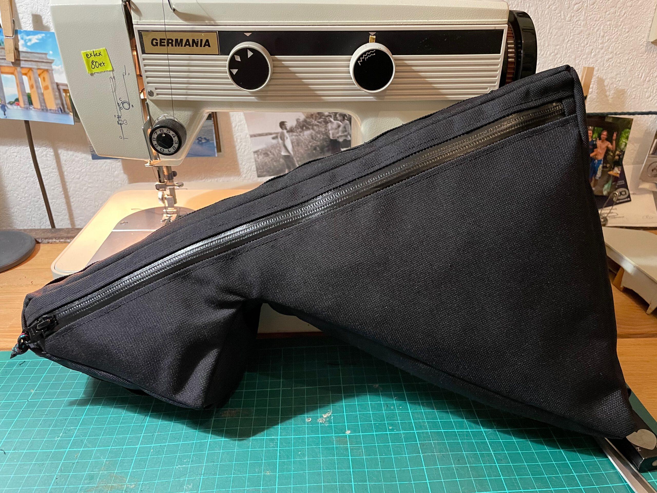 Rahmentasche halfframe 1-teilig von kirschpack in Schwarz vor einer Nähmaschine auf der Schneidematte