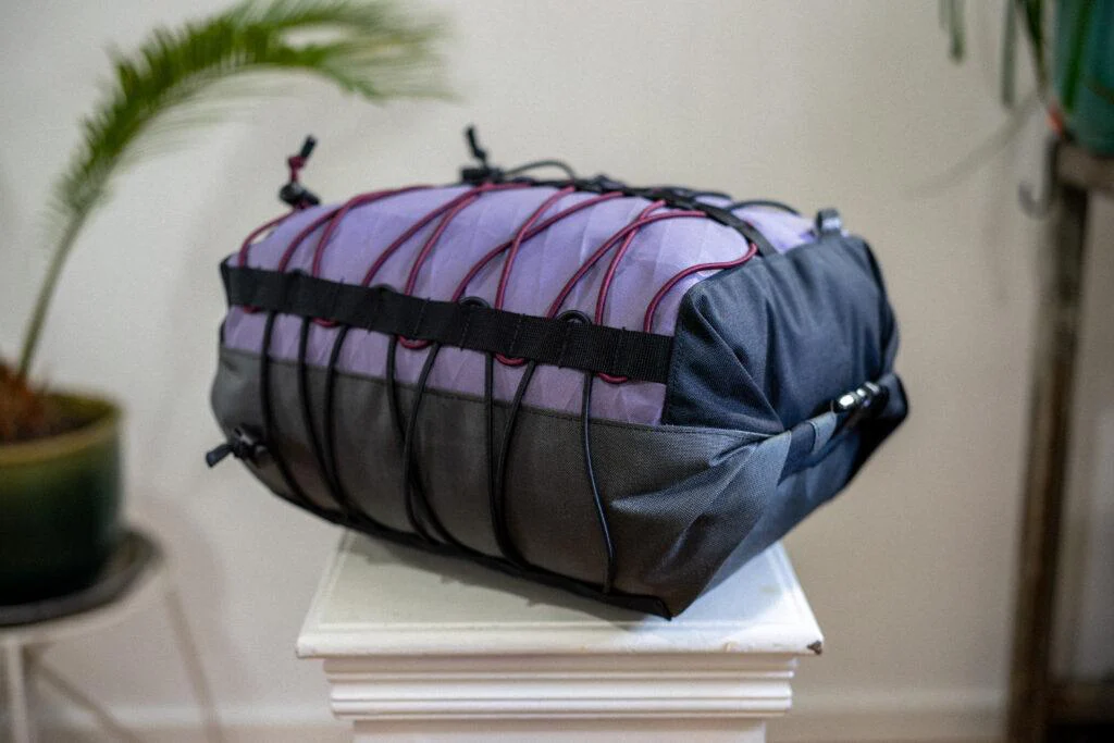 Lenkerrolle von kirschpack in Lila und Schwarz mit Gummizug-Schnürung auf einem weißen Hocker