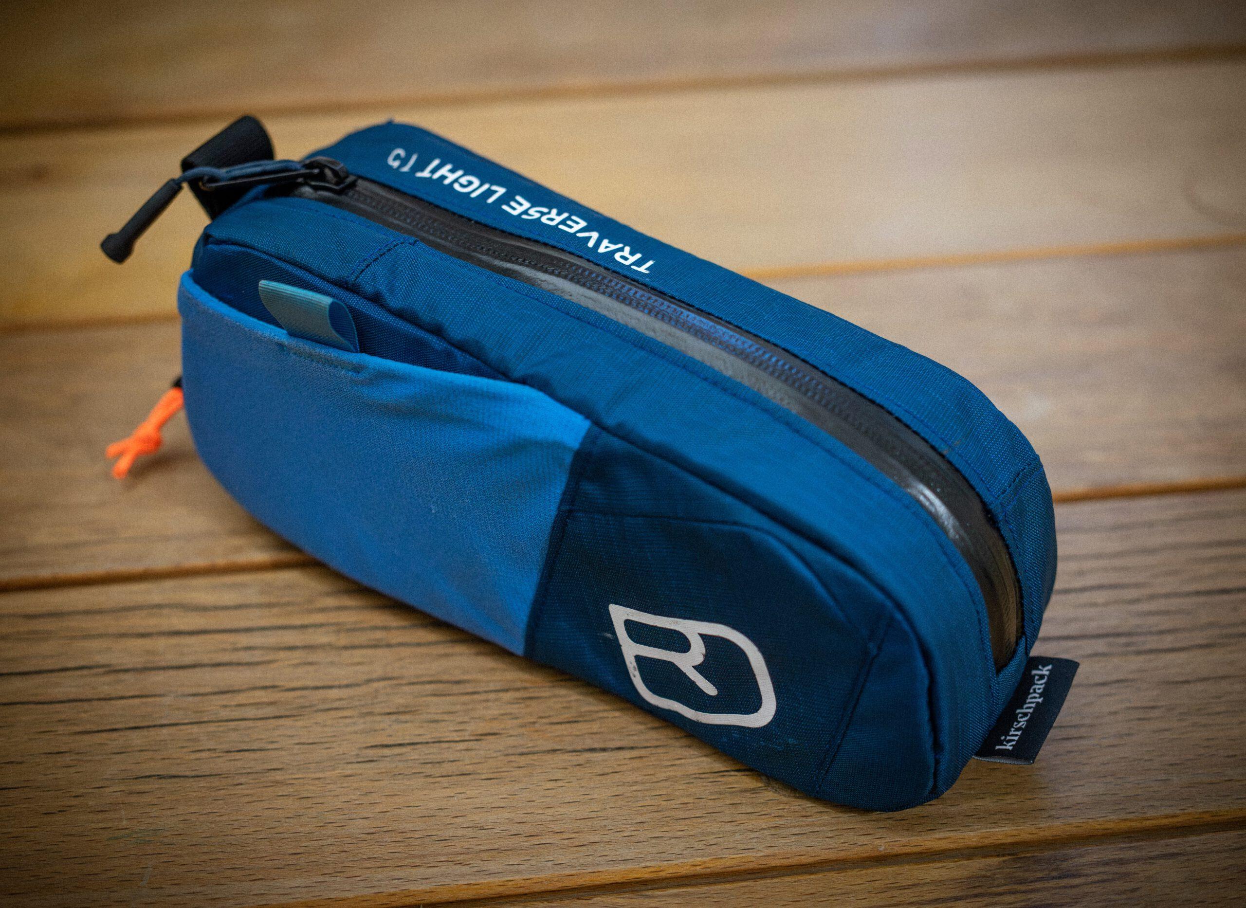 Oberrohrtasche »Dromedar« von kirschpack, upgecycelt aus einem blauen Ortovox-Rucksack, Seitenansicht auf Holztisch