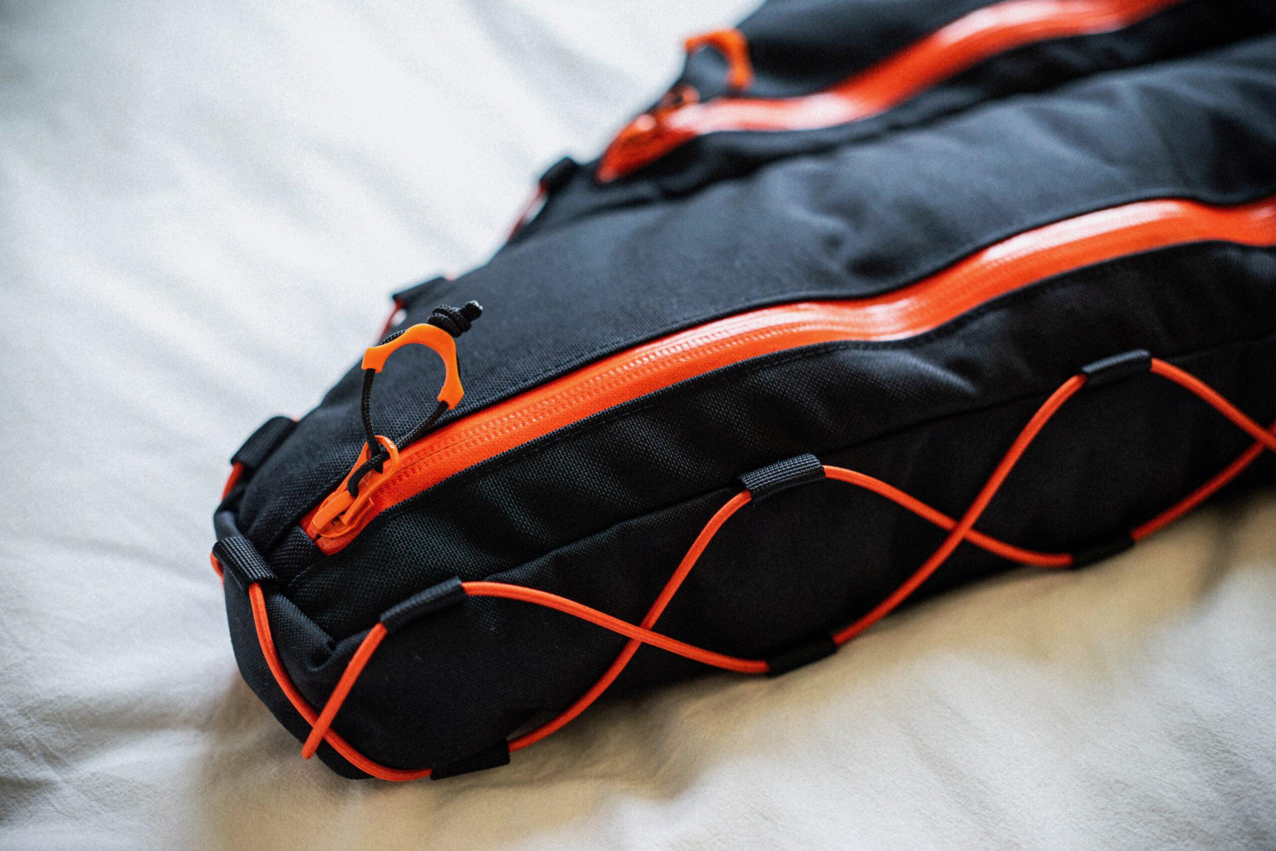 Rahmentasche fullframe 2-teilig von kirschpack, in Schwarz mit orangefarbenen Reißverschlüssen und Gummizug, Nahaufnahme